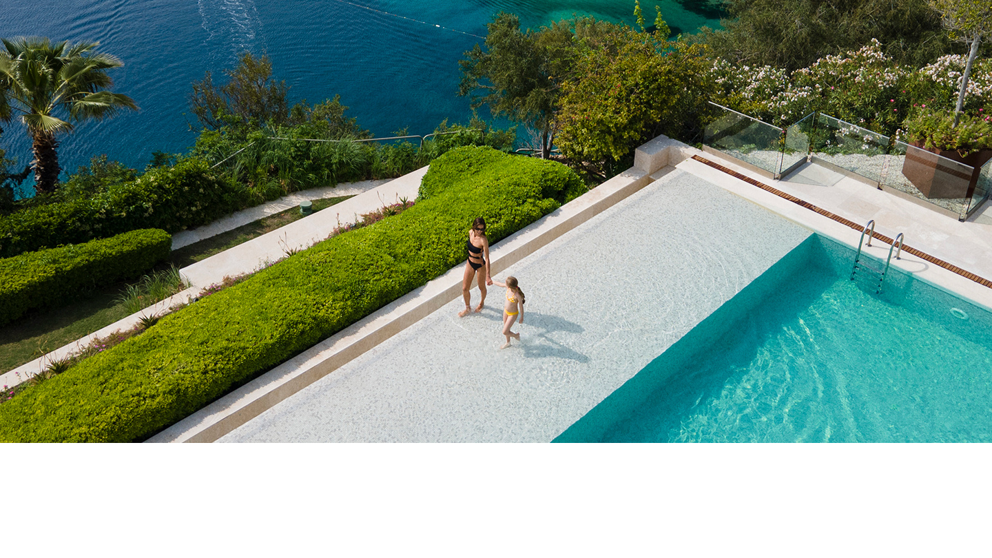 D Maris Bay havuzlu otelde anne ve çocuğun deniz manzaralı infinity havuz kenarında yürümesi